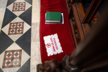 Polite Do Not Sit sign seen on the velvet seating of a famous English cathedral. The seating is for...