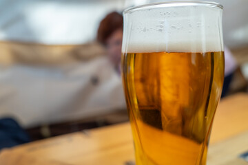 Draught beer with white bubbles in glass was taken in restaurant