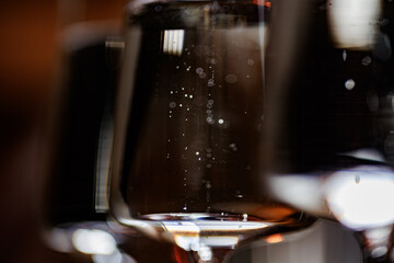 A close-up of a glass filled with red wine, showcasing delicate bubbles and rich hues against a...