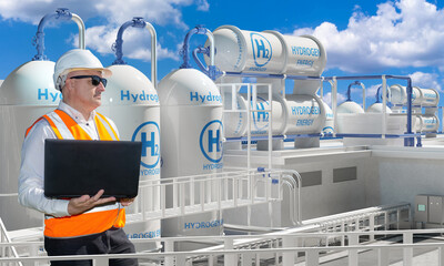 Man works for energy company. Engineer stands among hydrogen equipment. Mechanic with laptop...