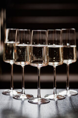 A stylish arrangement of five sparkling glasses gleams under soft lighting, ready for an elegant toast in a sophisticated setting