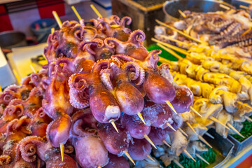 Squid, octopus, seafood and meats grilled in Japanese style in flea market in Japan. Japanese...