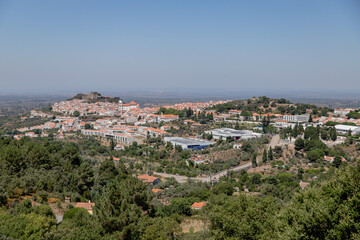 Fototapeta premium Panoramic view of Castelo de Vide, a historic village in Alentejo, Portugal, captured on a clear summer day from a scenic viewpoint, highlighting the medieval castle and white houses with red roofs.