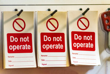 A close-up of a 'lockout station' displaying safety equipment and safety warning signs, used to securely lock out valves and other machinery during maintenance. 