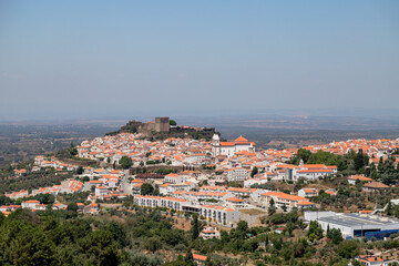 Fototapeta premium Panoramic view of Castelo de Vide, a historic village in Alentejo, Portugal, captured on a clear summer day from a scenic viewpoint, highlighting the medieval castle and white houses with red roofs.