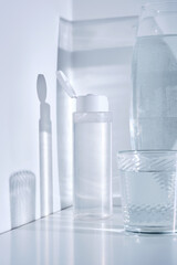 Bottle of cosmetic skin care product on white background with water reflections.