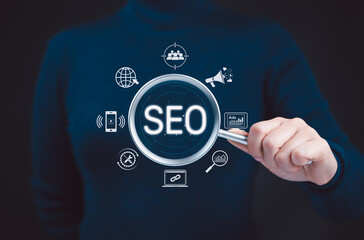 SEO Search Engine Optimization Concept. Businesswoman hold magnifying glass focusing on SEO,...