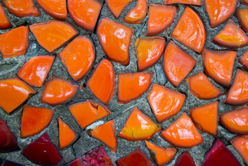 glass orange mosaic tiles of different sizes on concrete