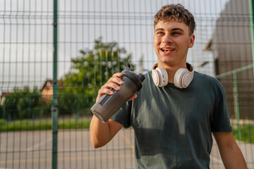 one young caucasian man teenager hold supplement shaker stand outdoor
