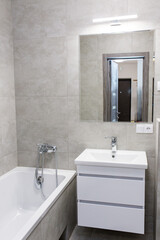 Modern bathroom with bathtub and wall mirror