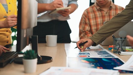 A diverse business team collaborates in a modern office setting, analyzing charts and graphs for marketing strategy. Focused discussions drive productivity and innovation. SACTR