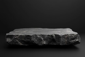Fototapeta premium Elegant dark stone platform showcasing natural texture against a black backdrop minimalist product display