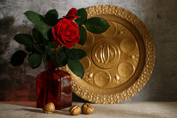Passover background with glass of wine and matzah and seder plate (with the inscriptions Pesach). Red Rose