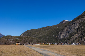 Snowy alpine slopes above residential houses under clear spring sky, Ötztal, Austria, 20 March...