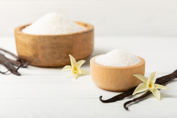 Aromatic vanilla sugar. Vanilla pods. Vanilla sticks, brown and white sugar in a bowl on a textured background. Vanilla flowers, spices and herbs for desserts and baking. Space for text. Copy space