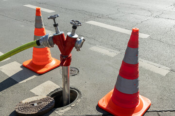 close-up Fire hydrant is connected. It is surrounded by cones for the attention of passers-by and...