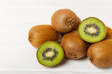 Kiwi on wooden background. Whole fruit and slices pieces of green kiwi on table. fresh ripe juicy...