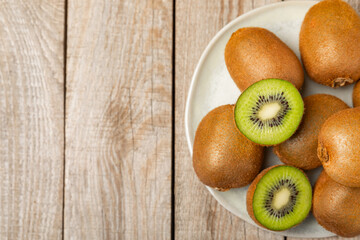 Kiwi on wooden background. Whole fruit and slices pieces of green kiwi on table. fresh ripe juicy...