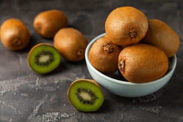 Kiwi on wooden background. Whole fruit and slices pieces of green kiwi on table. fresh ripe juicy...