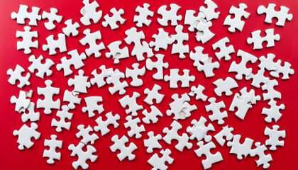 White puzzle pieces on red background, top view