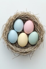 Pastel easter eggs nestled in straw against white background