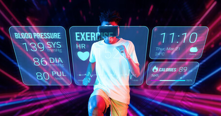 Healthy man making running posture while looking at hologram. Attractive male model playing fitness...