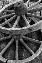 Fragment of a wooden wheel. A wooden wheel from an ancient cart lies on boards. View of a fragment of ancient technology for making a wheel from natural materials.