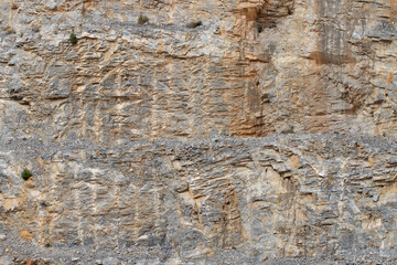 Behind the Mediterranean coastline, the slopes reveal detailed soil layers and formations,...