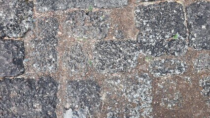 A dirt path paved with large stones, the stone courtyard of an ancient castle in Thailand, the floor of a castle in the past. Texture Image.