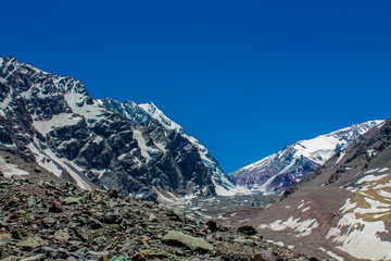 Andes mountains beautiful landscape in early spring with melting snow on the mountain slopes and lakes. Volcano San Jose in the high altitude Andes in Santiago de Chile area