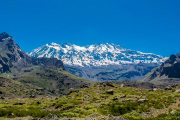Obraz premium Andes mountains beautiful landscape in early spring with melting snow on the mountain slopes and lakes. Volcano San Jose in the high altitude Andes in Santiago de Chile area