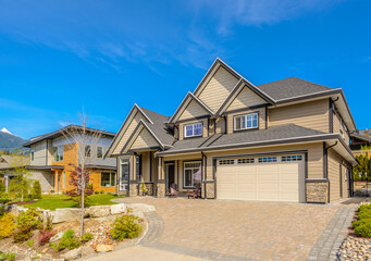 Garage door in luxury house with trees and nice landscape in Summer in Vancouver, Canada, North America. Day time on June 2024.