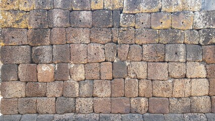 Ancient old brick stone texture pattern background. Ancient castle stone wall in Thailand, a fence made of large stones stacked in many layers.