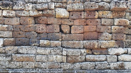 Old brick wall background, ancient castle stone wall in Thailand, fence made of large stones stacked in layers, ancient construction.