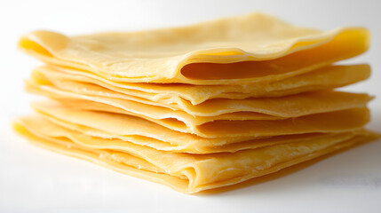 Lasagna sheets slightly overlapped, arranged in a neat row on a white surface, capturing the fine texture and golden hue of each sheet.