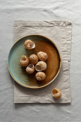 Round plate with a rim in a warm colors on a beige cotton tablecloth. Minimalistic composition with...