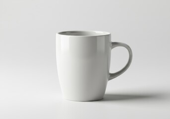 Obraz premium A simple white ceramic mug with a handle against a plain white background in a studio setting