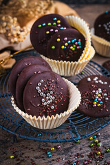 Artisan homemade fine dark chocolate thaler  decorated with colorful sugar pearls in muffin moulds