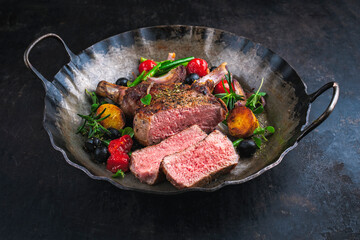 barbecue dry aged veal chop sliced with Mediterranean vegetable and fried potatoes served in a...