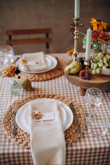 Elegant outdoor table setting with a checkered tablecloth, woven placemats, and figs