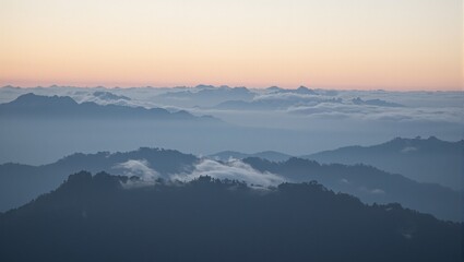 Obraz premium Ethereal sunrise over misty mountain peaks with rolling fog creating a dreamlike landscape