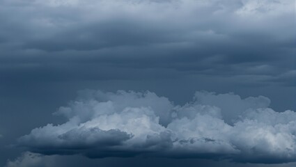 Obraz premium Dark storm clouds loom ominously swirling with deep gray tones in a dramatic display of approaching inclement weather