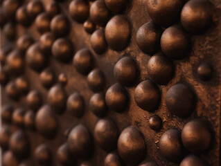 A CloseUp of a Detailed Textured Metal Surface Featuring Raised Bumps and Patterns