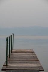 Obraz premium Minimalist Wooden Dock Leading into Misty Water