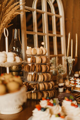 A beautifully arranged dessert table featuring delightful macarons, colorful cupcakes, and elegant rustic decor