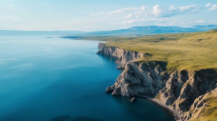 Majestic coastal cliffs overlooking expansive ocean with clear blue skies