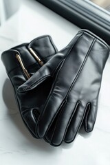 Naklejka premium Elegant black leather gloves with gold zipper detail on marble surface