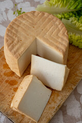 Cheese collection, piece of round fresh smoked Spanish goat cheese close up