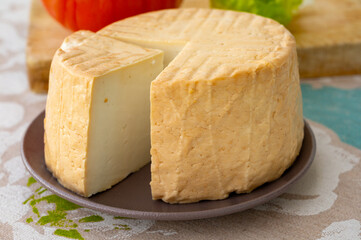 Cheese collection, piece of round fresh smoked Spanish goat cheese close up