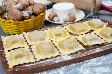 Italian food, fresh home made stuffed pasta ravioli dumplings with ricotta soft cheese and champignons porcini mushrooms, Parma, Emilia Romagna, Italy